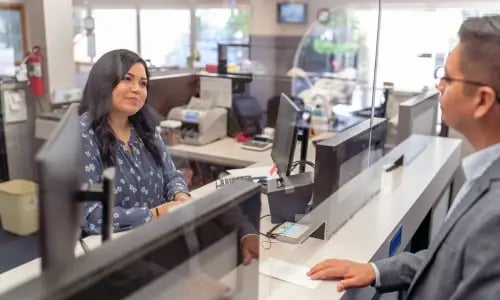 Caixa de banco a ajudar um homem a sair de uma janela