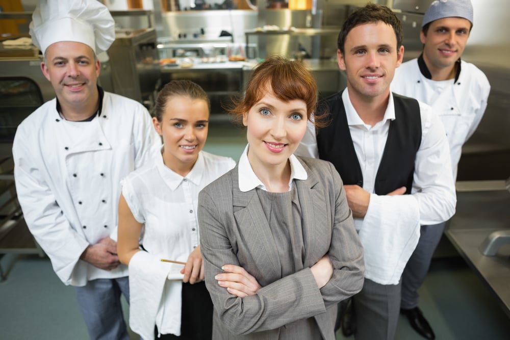 Gestora gira a posar com o pessoal numa cozinha moderna