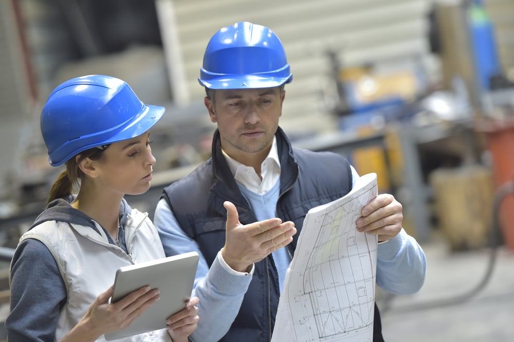 Engenheiros de fábrica mecânicos que lêem instruções