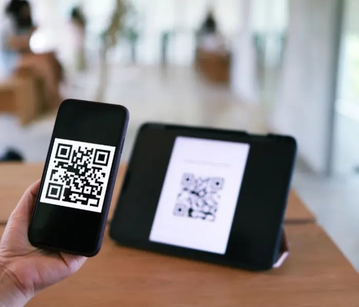 Pessoa a ler o código QR num tablet com o iPhone 