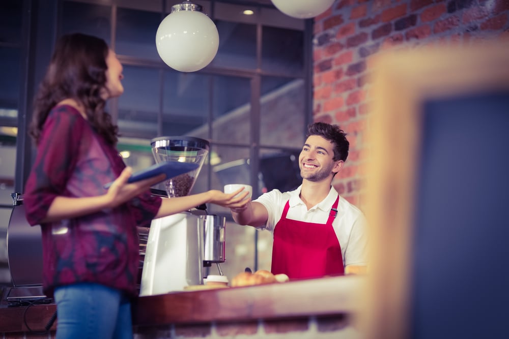 Empregado de mesa sorridente a servir um cliente num café-1