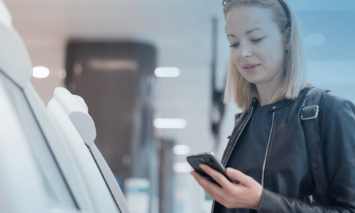 Mulher ao telefone a utilizar uma máquina self-service de fotocópias