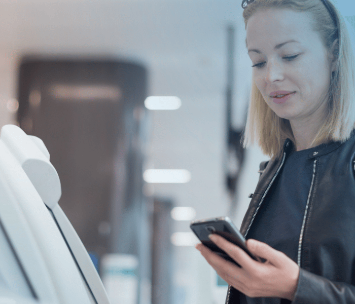 Mulher ao telefone a utilizar uma máquina de self-service para copiar