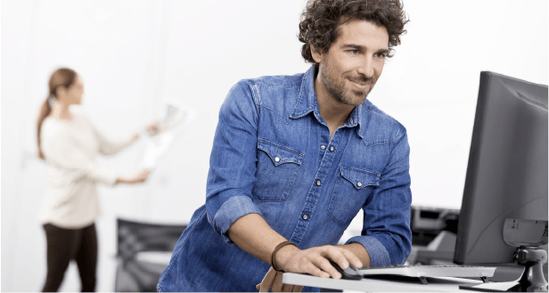 Homem de camisa azul abotoada a utilizar o computador