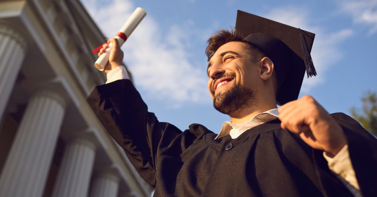 Homem que termina o curso superior segurando o seu diploma 