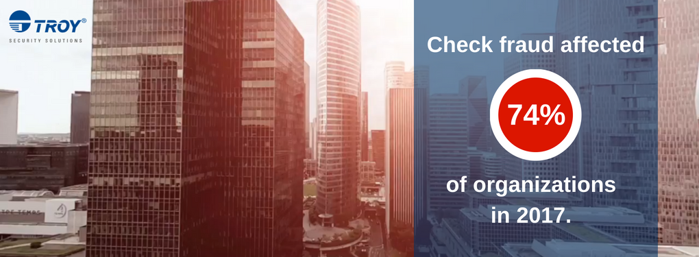 Cityscape background with text that reads Check fraud affected 72% of organizations in 2017