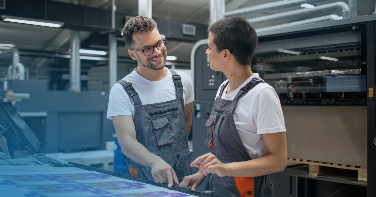 Trabalhadores de uma gráfica que utilizam uma impressora plana UV
