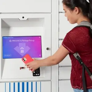 Estudante a utilizar o cacifo de encomendas inteligentes com o telemóvel Estudante a utilizar o cacifo de encomendas inteligentes com o telemóvel